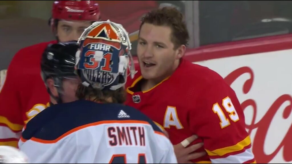 Mike Smith throws a few shots to Matthew Tkachuk during a scrum between the Oilers and Flames