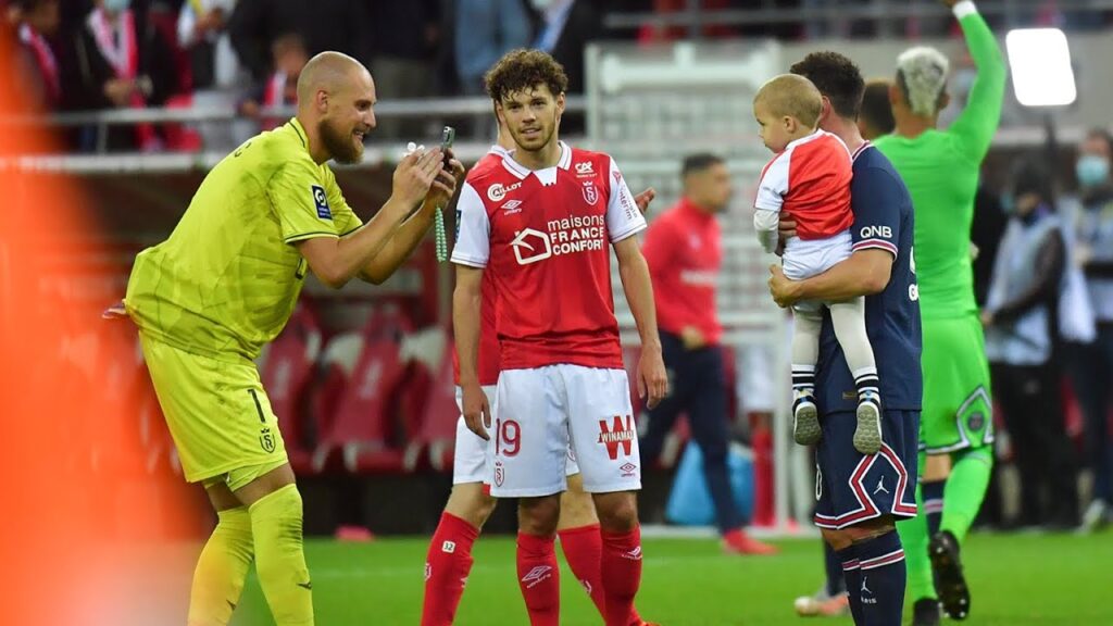 Leo Messi taking a picture with Reims goalkeeper's child after the match