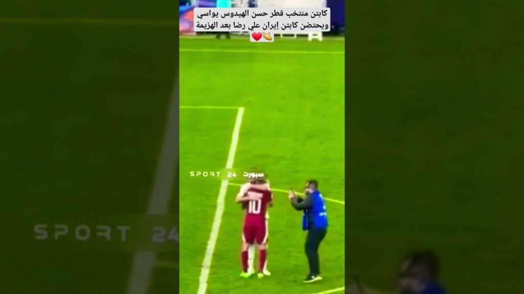 قائد منتخب قطر حسن الهيدوس يذهب ليواسي لاعب إيران علي رضا جاهنباخش بعد الخسارة