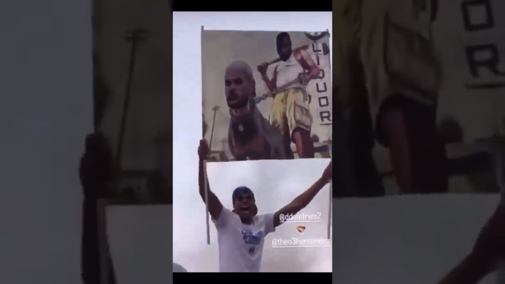 Denzel Dumfries holding up a poster of him holding Theo Hernandez on a leash during the celebration