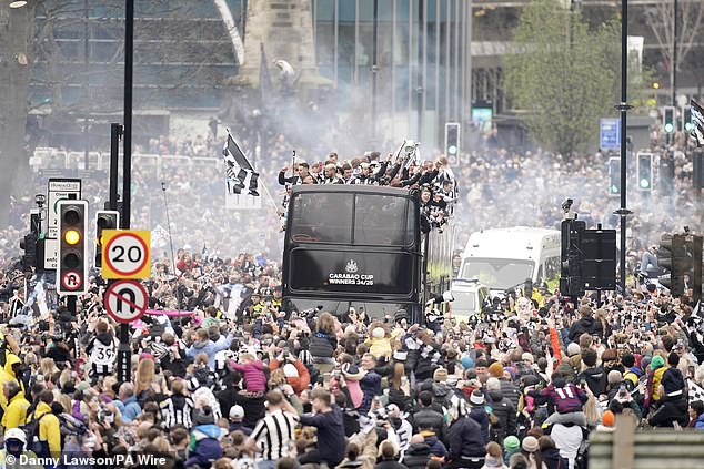 Newcastle United fans watch on as the players pass by aboard an open top bus during the Carabao Cup trophy parade in Newcastle today