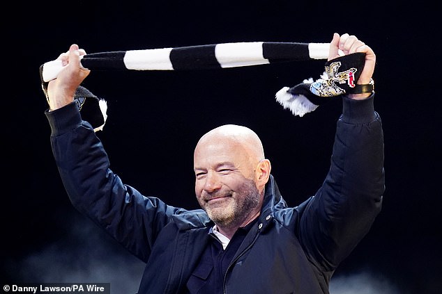 Newcastle legend Alan Shearer holds his black and white club scarf aloft as he takes to the stage as part of celebrations following the club's Carabao Cup victory