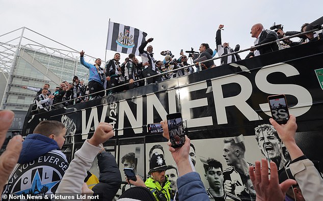 Newcastle United fans and staff wave to fans as they pass on their open top bus victory parade
