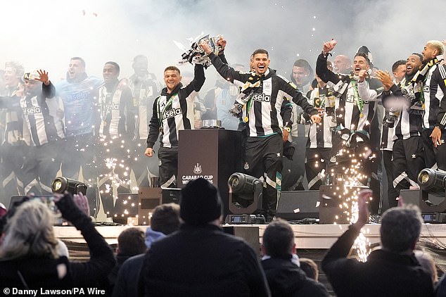Newcastle captain Bruno Guimarães (right) and defender Kieran Tripper hold the trophy at the club's victory celebrations
