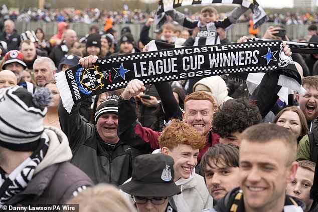 A Newcastle fan holds up a scarf proclaiming them 'League Cup Winners 2025' following their triumph over Arne Slot's Liverpool