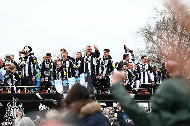 The Newcastle United players and staff take in the atmosphere as they pass fans on the open top bus