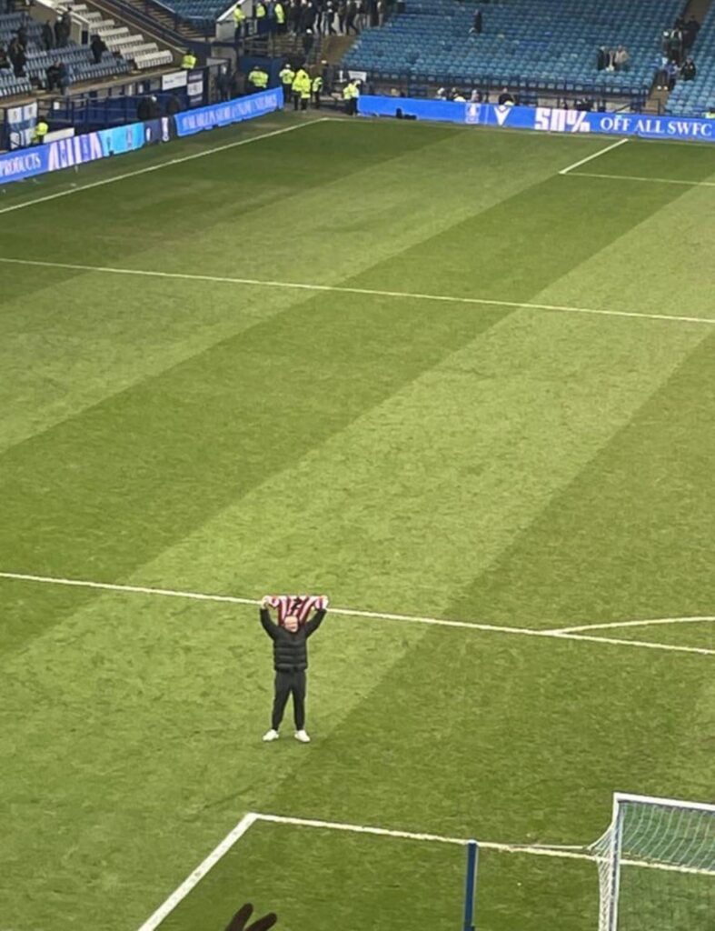 Chris Wilder holds George Baldock's shirt to the away supporters, after beating Sheffield Wednesday in the Steel City Derby