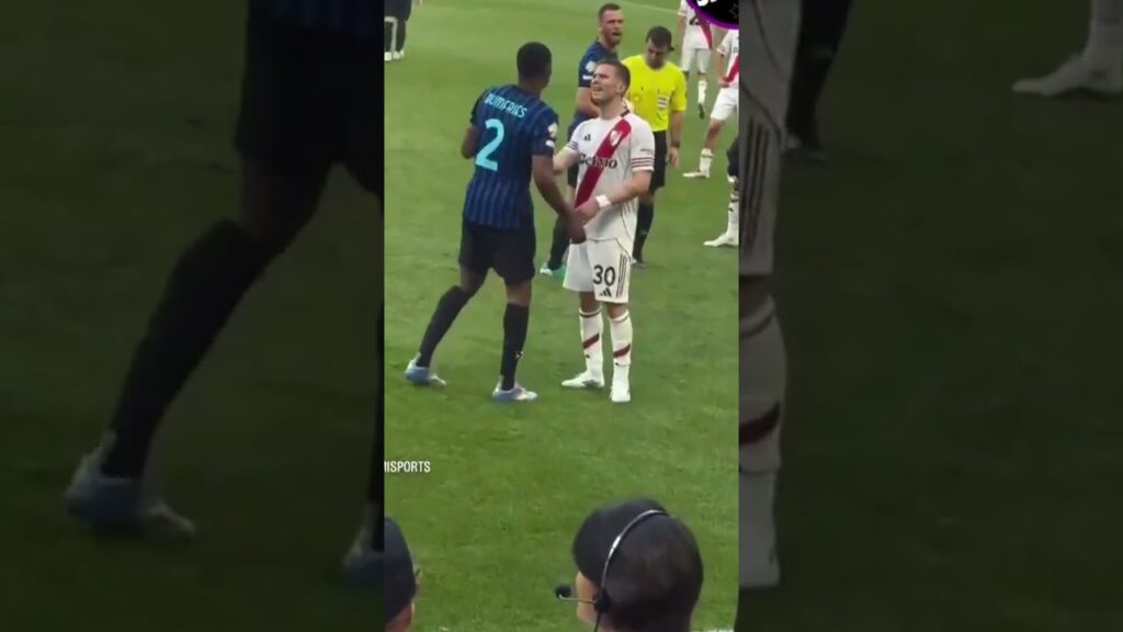 Marcos Acuña showing Denzel Dumfries his shin pad with the World Cup trophy.