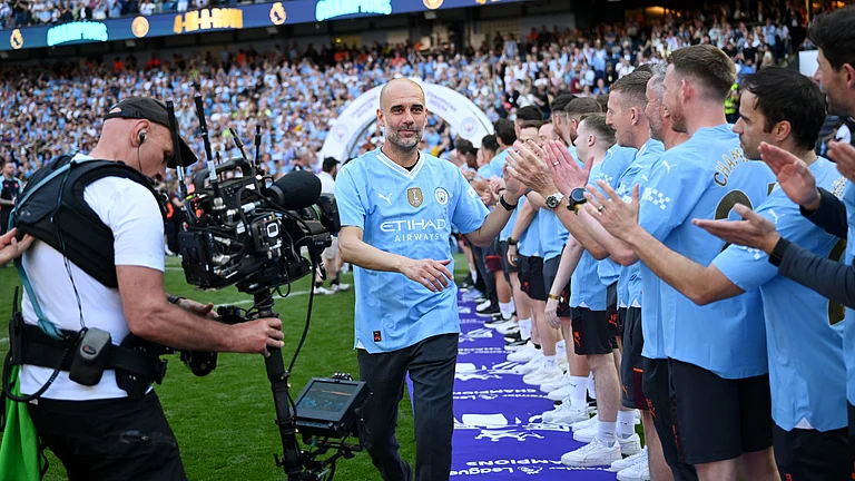 Pep Guardiola walks down to celebrate with Manchester City players en route to lifting the 2023/24 Premier League trophy. - File Photo