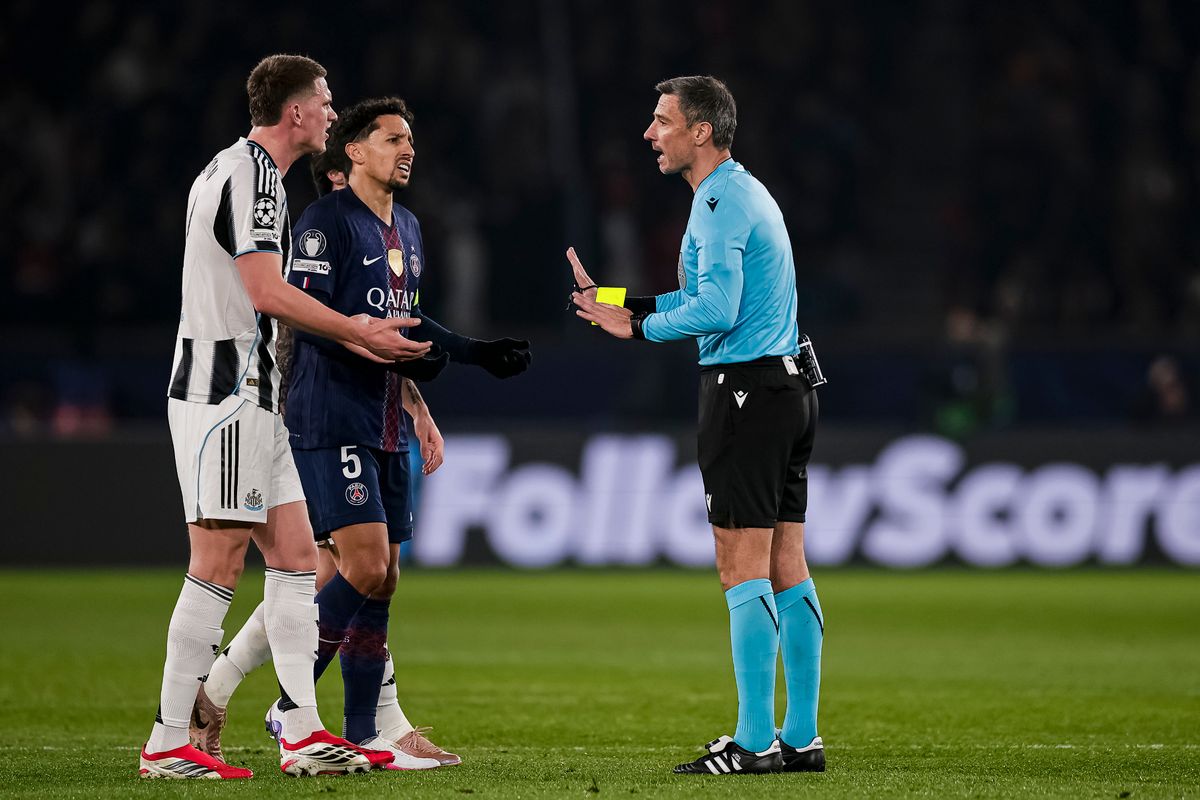 Referee Slavko Vincic (R) talks to Marcos Correa of Paris Saint-Germain and Newcastle United's Sven Botman