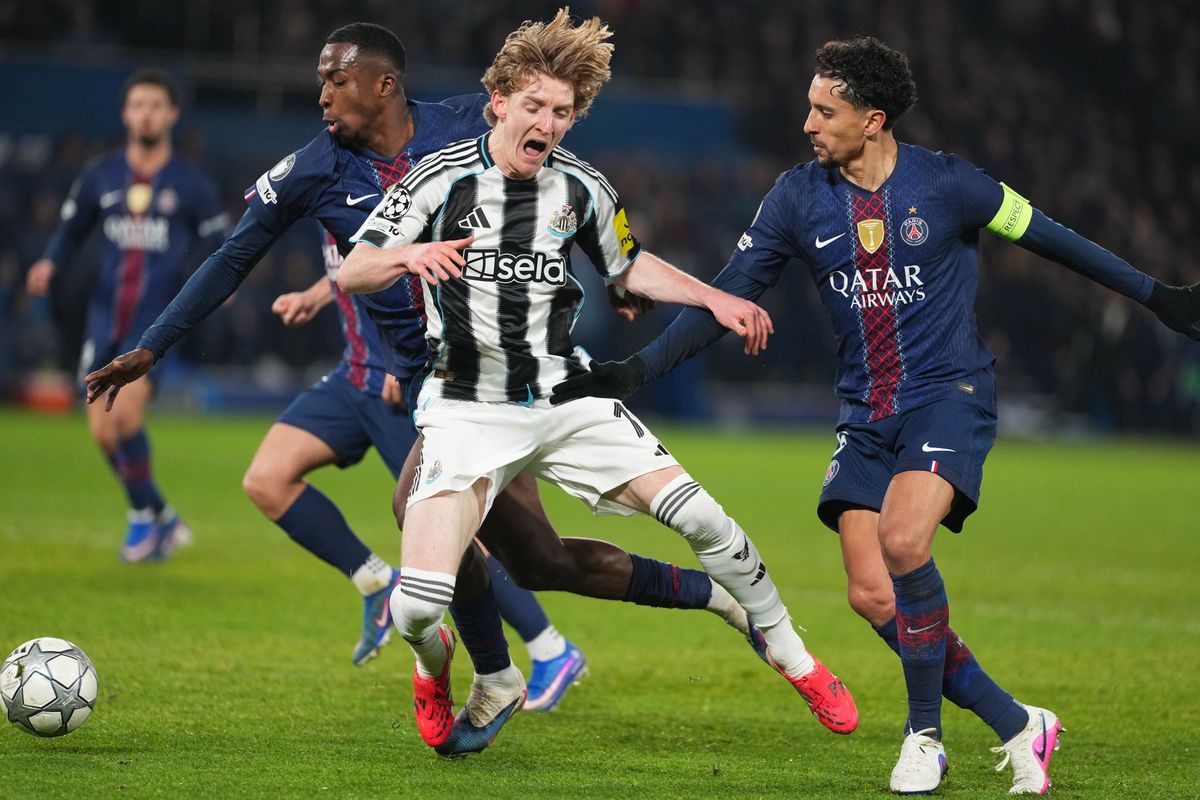 Anthony Gordon of Newcastle is challenged by Willian Pacho of PSG and Marquinhos of PSG