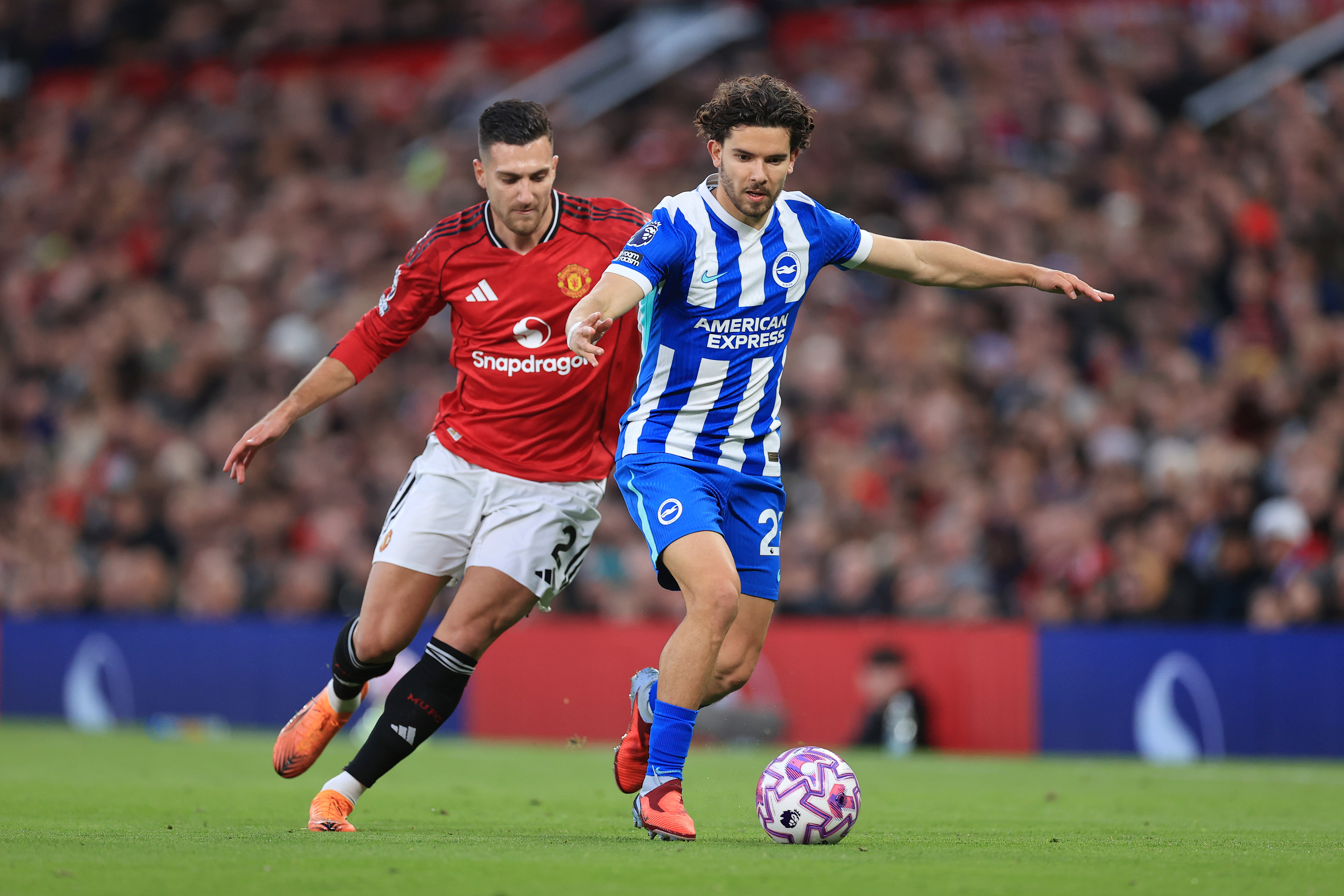 Ferdi Kadioglu of Brighton & Hove Albion battles with Diogo Dalot of Manchester United during a Premier League match.
