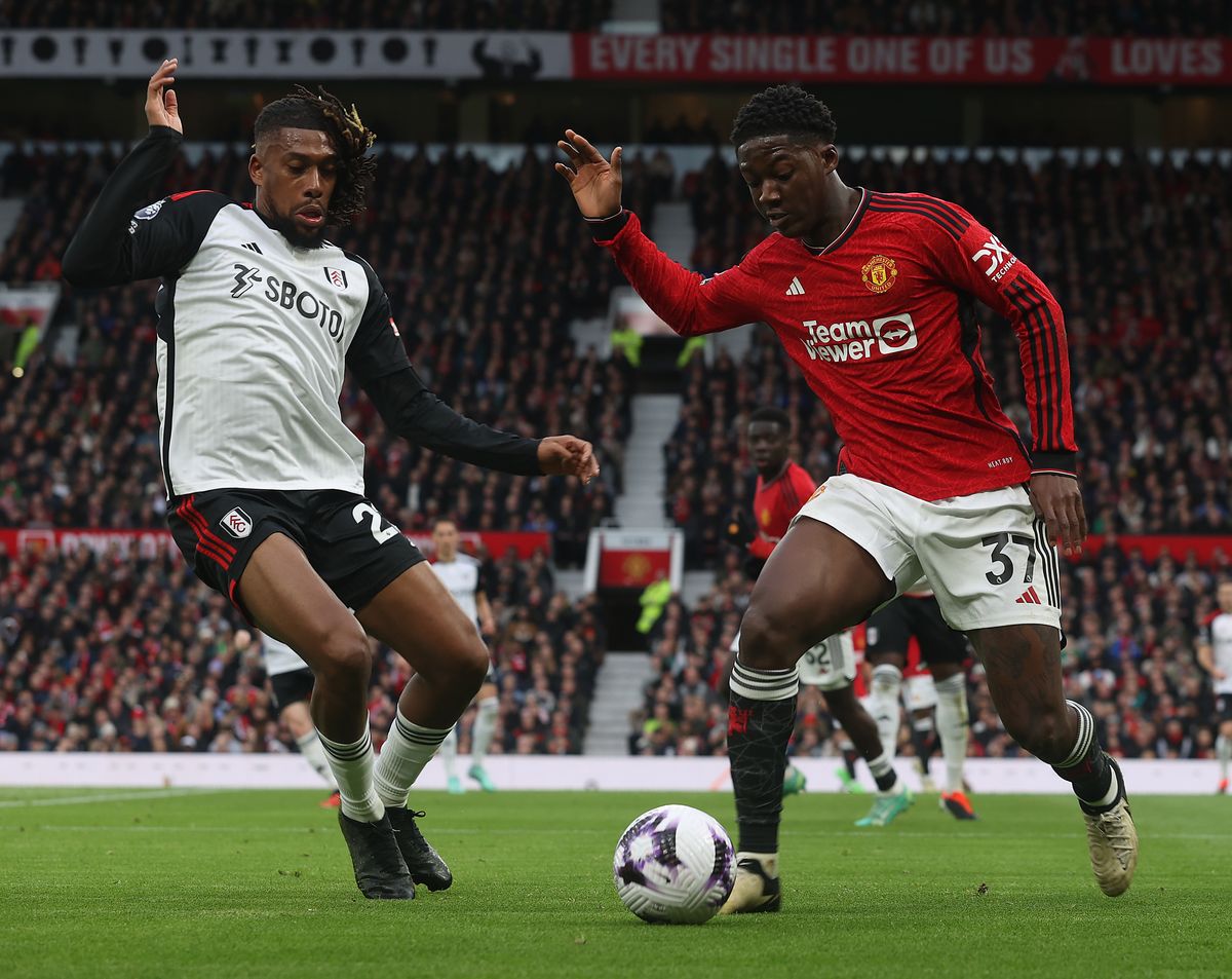 Kobbie Mainoo of Manchester United in action with Alex Iwobi of Fulham during the Premier League match between Manchester United and Fulham FC at Old Trafford on February 24, 2024 in Manchester, England. 