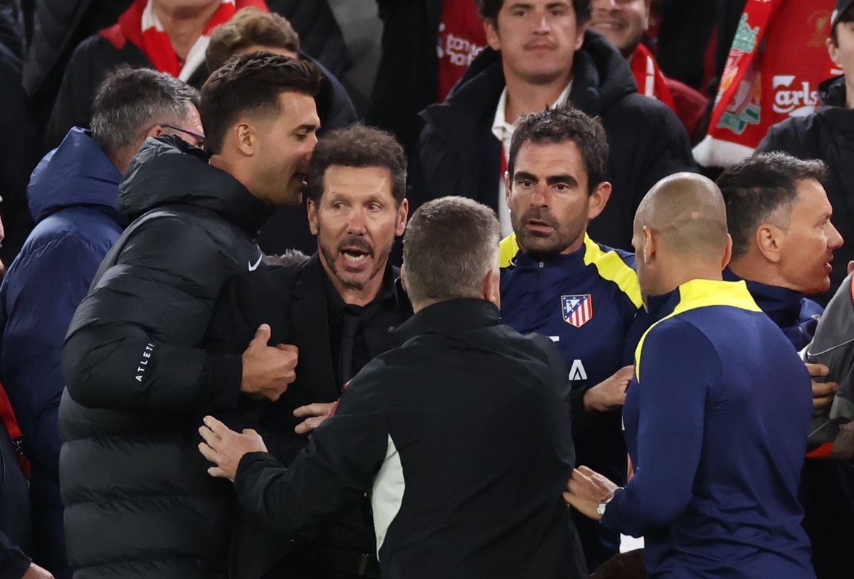 Atletico Madrid manager Diego Simeone is restrained as he confronts fans after Liverpool's late Liverpool winning goal
