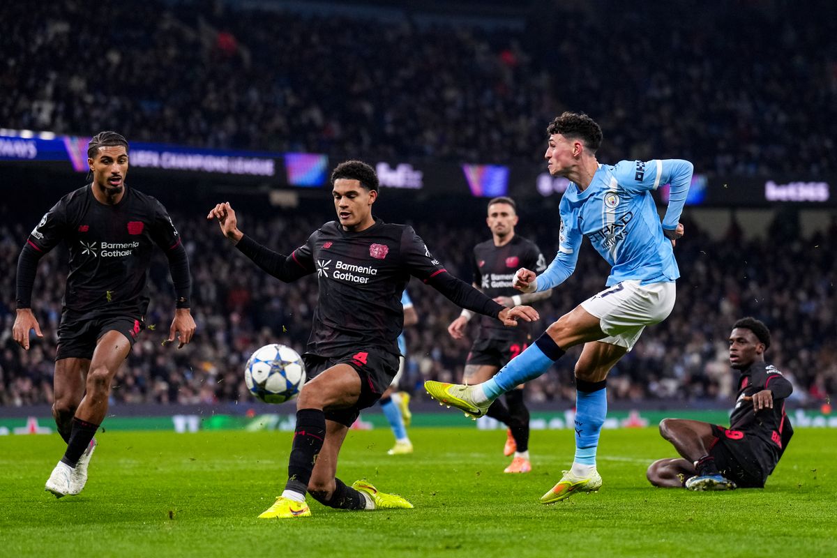 Bayer Leverkusen defender Jarell Quansah (C) challenges England team-mate Phil Foden of Manchester City (R)