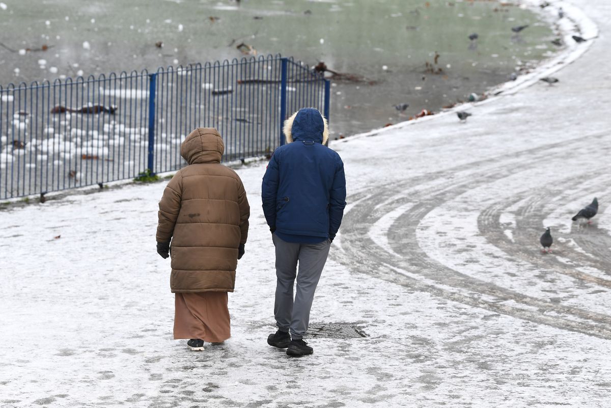 Walkers in the snow and ice in Sefton Park last month