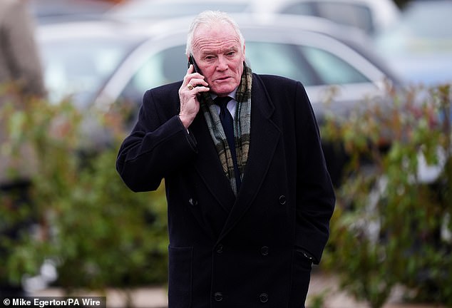 Leeds United legend Eddie Gray is pictured on the phone as he arrived at the crematorium