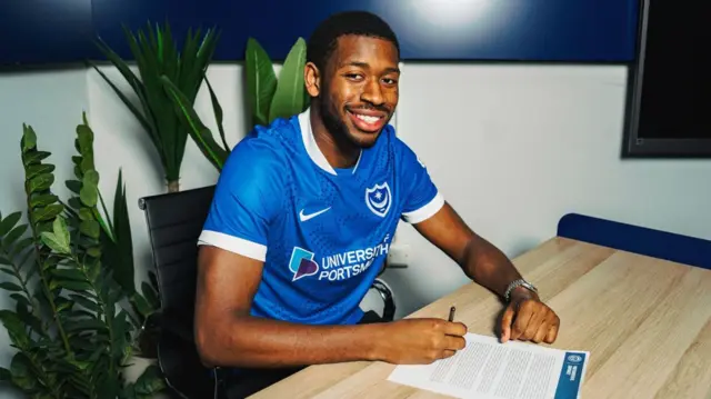 Ebou Adams signing his contract with Portsmouth