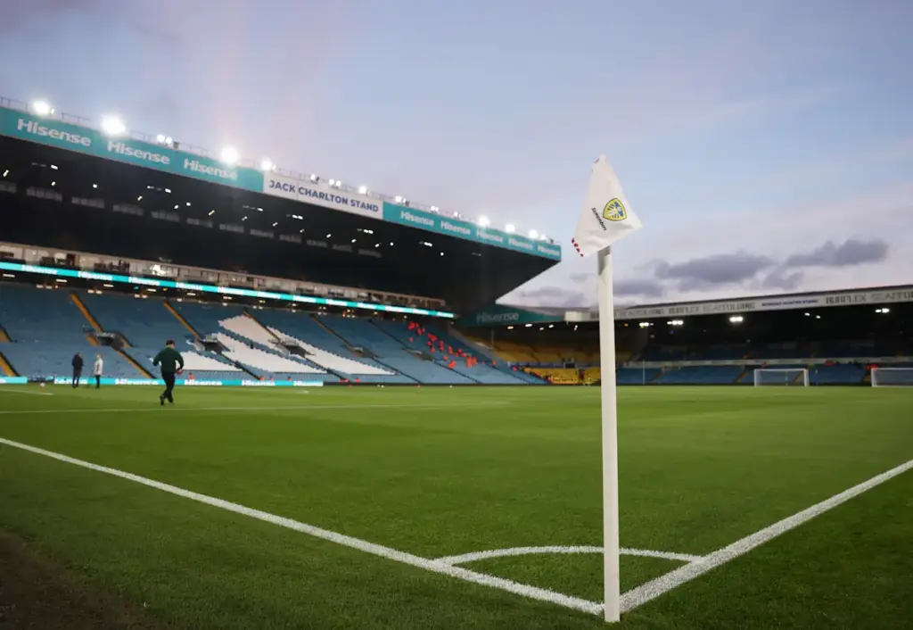 Leeds United's Elland Road seen empty, from the inside in the early evening with the floodlights on and the backdrop of a lush green pitch and a light blue sky