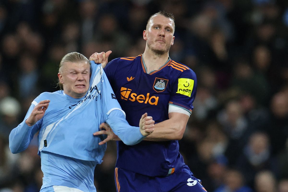 Newcastle United's Dan Burn challenges Man City's Erling Haaland