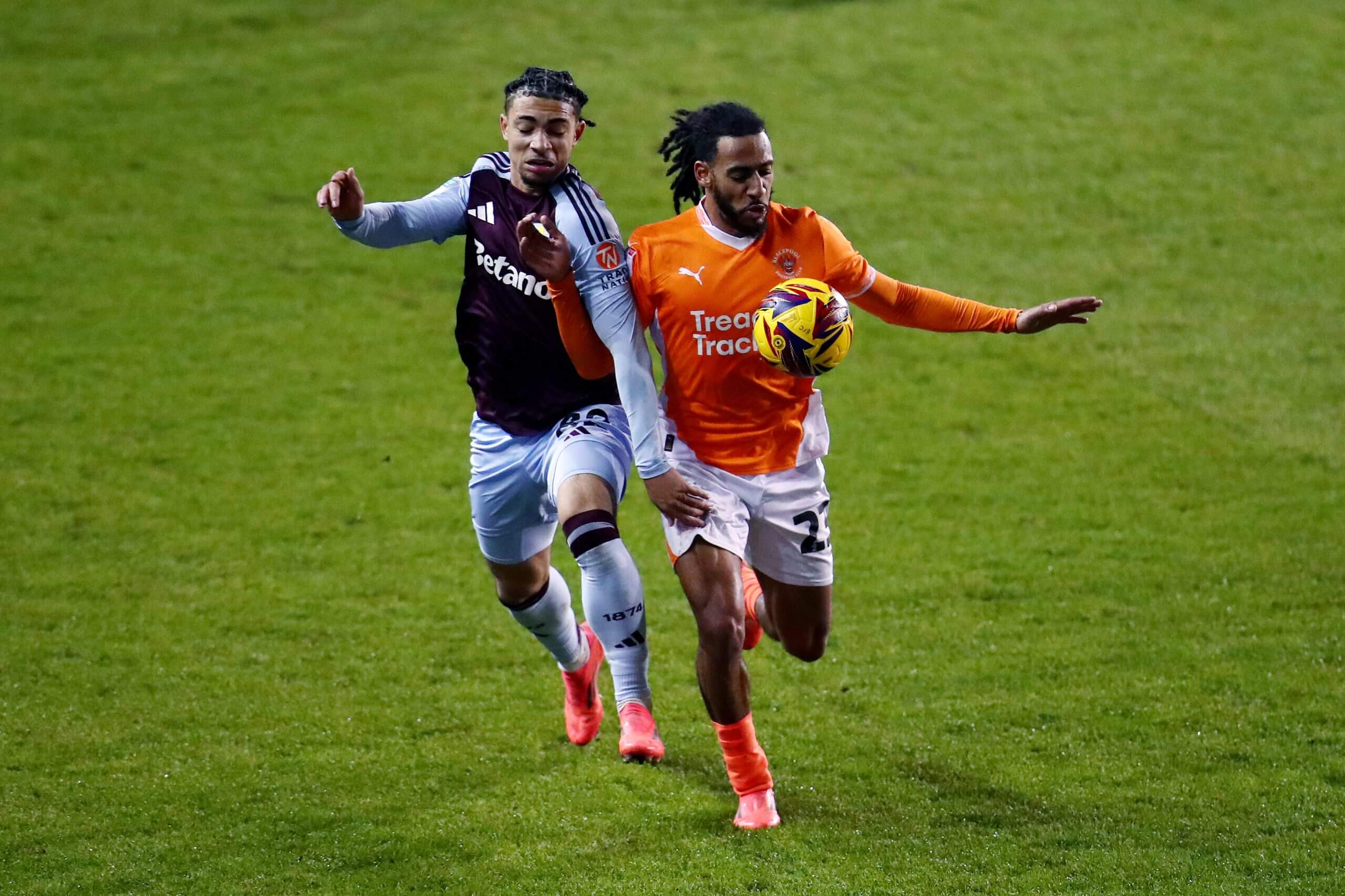 Luka Lynch, sporting decidedly less flamboyant hair, battles with Blackpool's Dominic Thompson during the Vertu Trophy in December 2024