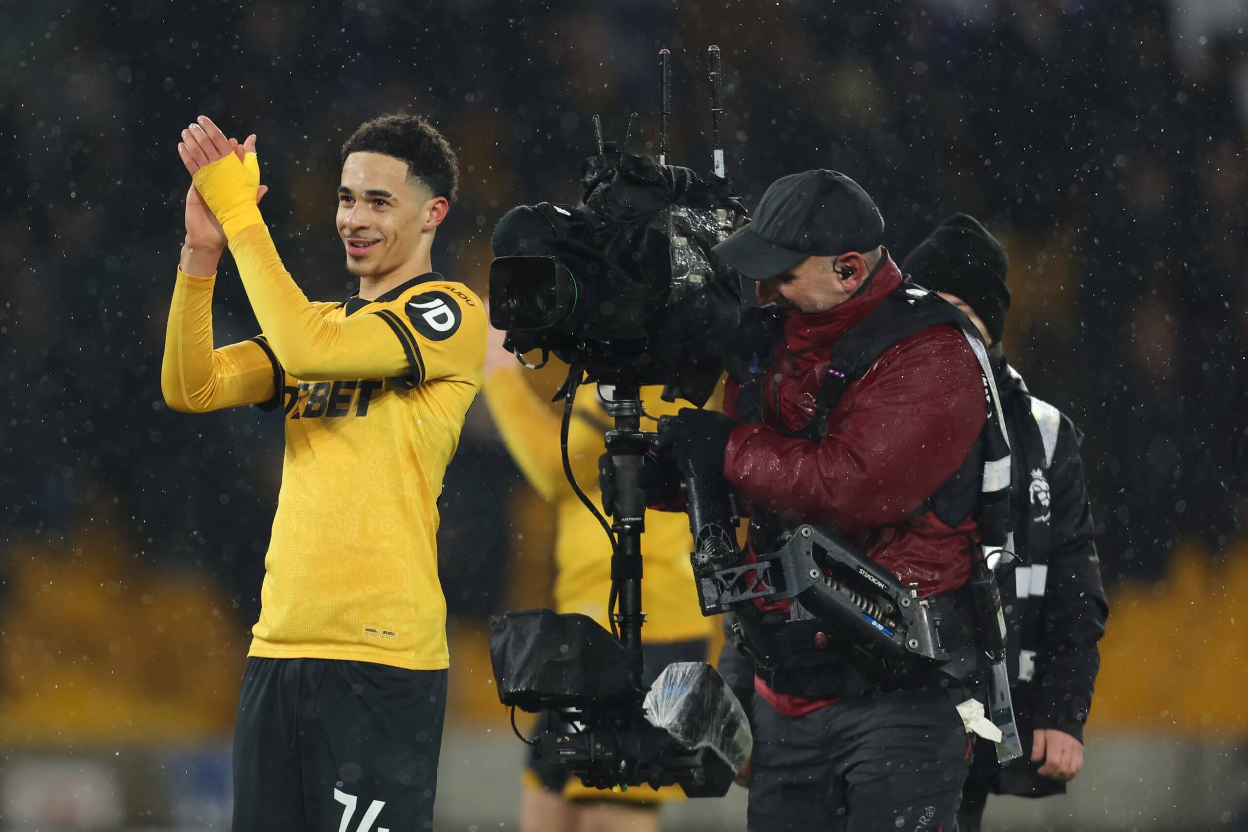 Tom Edozie applauds as a cameraman films next to him