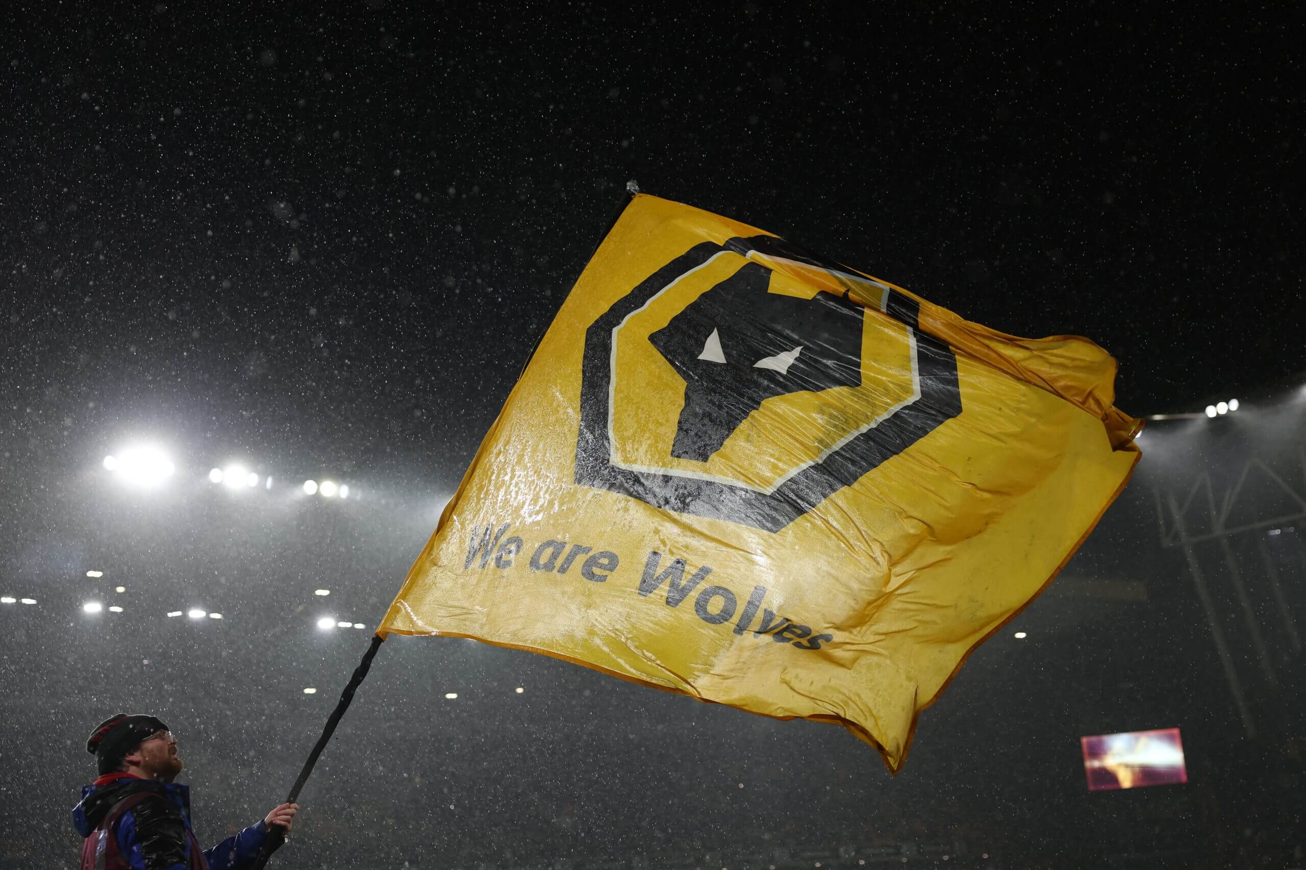 A Wolverhampton Wanderers flag is waved prior to kick off in the rain at Molineux