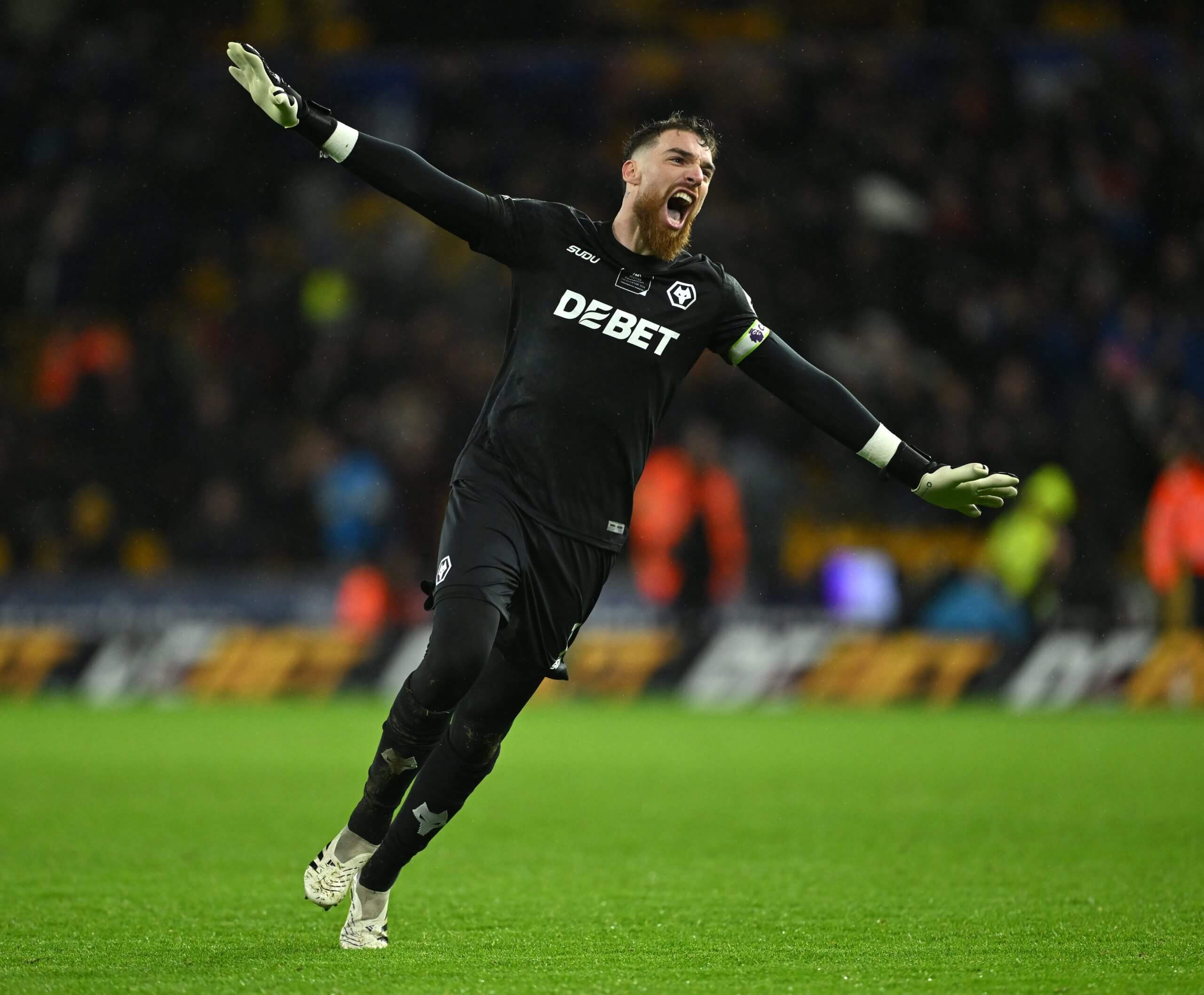 The Wolves goalkeeper celebrates, arms wide apart, as Wolverhampton Wanderers celebrates after team-mate Rodrigo Gomes scores his team's second goal