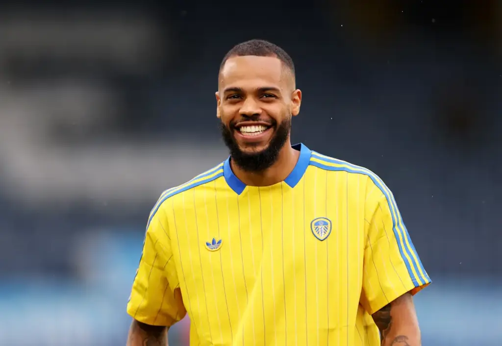 Leeds United striker Lukas Nmecha smiles on the pitch as he prepares for a game