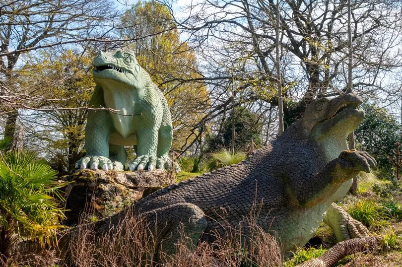 Two historic and famous Iguanodon dinosaur sculptures on an island in the public Crystal Palace Park in South East London. The dinosaurs were constructed in the park in 1854 when the former 1851 Great Exhibition glass ‘palace’ was moved to Sydenham after the exhibition closed. The new, extensive pleasure gardens contained a collection of around 30 ‘dinosaurs’ and other extinct creatures, which are now known to be anatomically inaccurate. They are, however, a famous and much-loved attraction in South East London. The sculptures were created by one of the 19th-century’s best-known natural history sculptors, Benjamin Waterhouse Hawkins (1807-1894). The landscape in which they are set was designed by Joseph Paxton, designer of the Crystal Palace glass building.