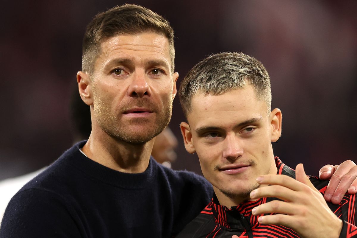 Xabi Alonso, Head Coach of Bayer 04 Leverkusen, embraces Florian Wirtz of Bayer 04 Leverkusen a full-time following the team's draw in the Bundesliga match between FC Bayern München and Bayer 04 Leverkusen at Allianz Arena on September 28, 2024 in Munich, Germany.