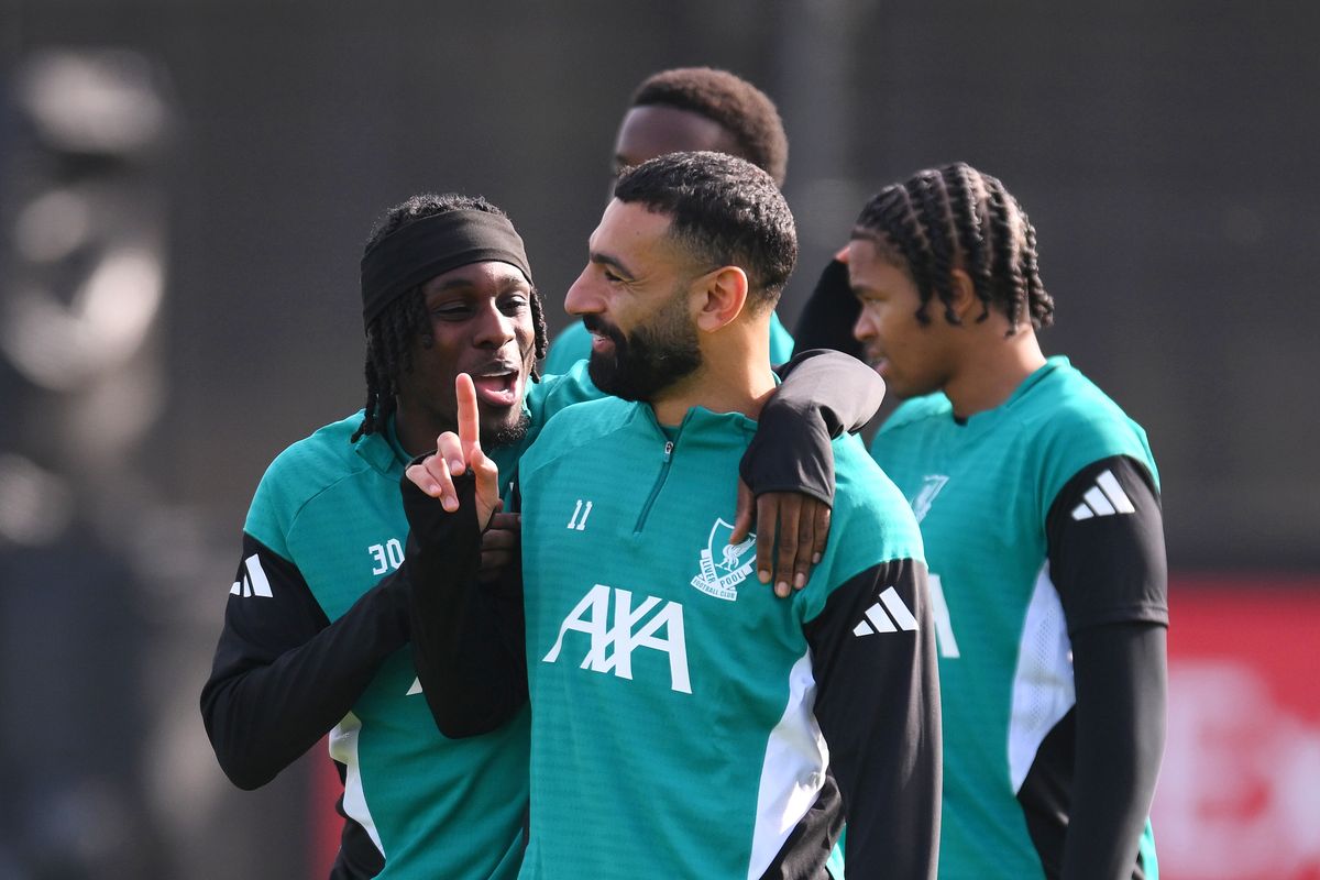 Jeremie Frimpong of Liverpool reacts with team-mate Mohamed Salah at AXA Training Centre on September 29 2025