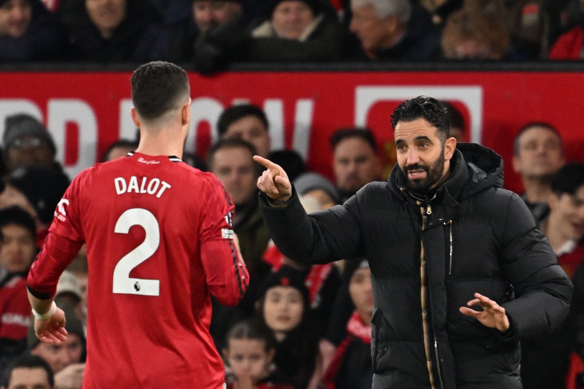 Manchester United's Portuguese head coach Ruben Amorim (R) speaks with Manchester United's Portuguese defender #02 Diogo Dalot (L) during the English Premier League football match between Manchester United and Bournemouth at Old Trafford in Manchester, north west England, on December 15, 2025.