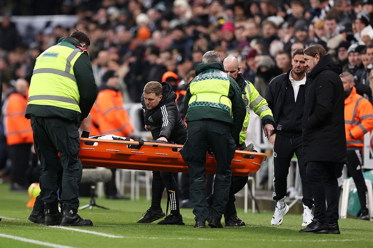 Fabian Schar of Newcastle United is consoled by Eddie Howe, manager of Newcastle United, after being stretchered off following an injury vs Leeds United