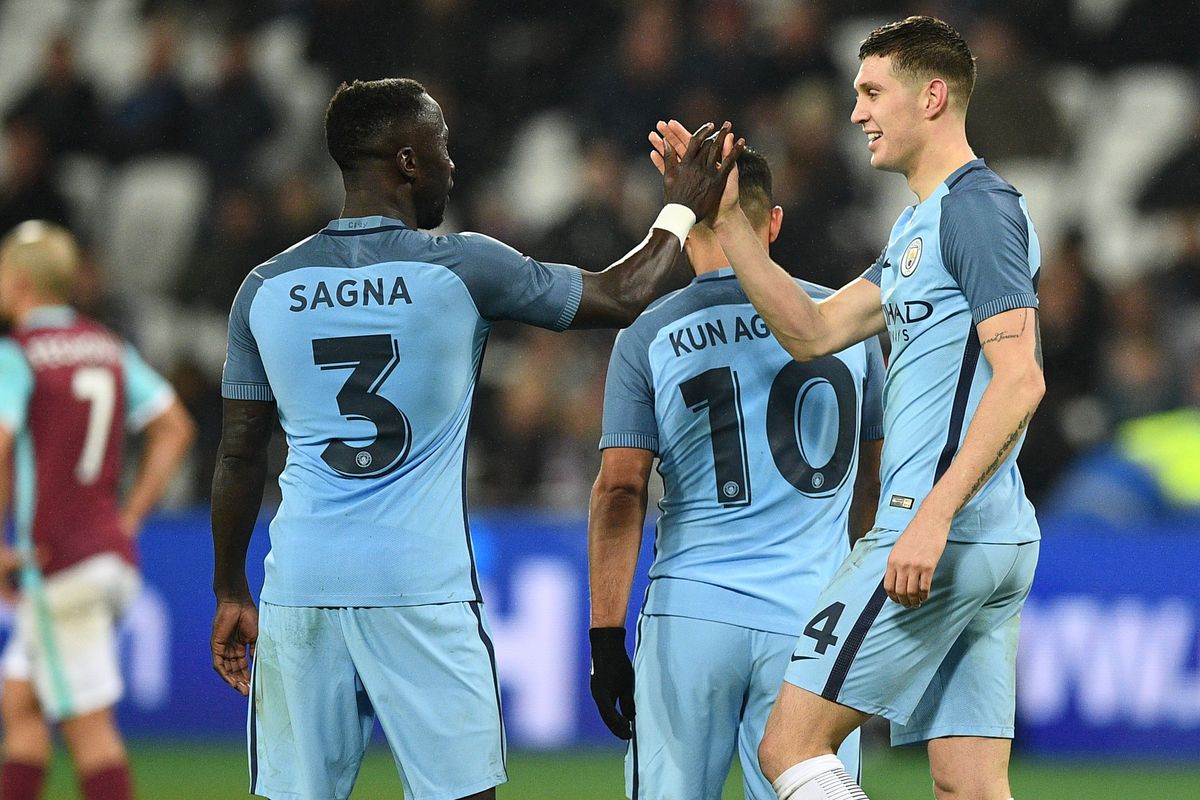 Manchester City's English defender John Stones celebrates with Manchester City's French defender Bacary Sagna after scoring their fifth goal during the English FA cup third round football match between West Ham United and Manchester City at the London Stadium in east London on January 6, 2017. 