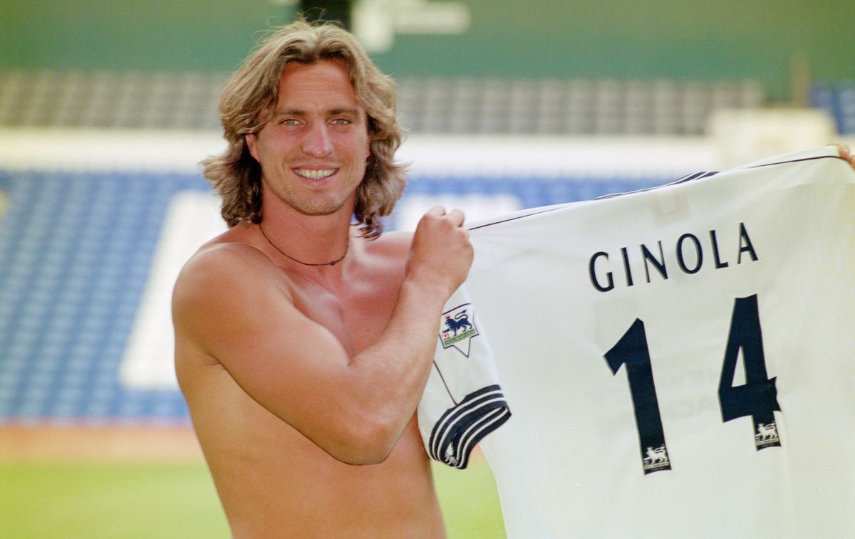 A bare chested David Ginola poses with his numbered Spurs shirt at the press conference to herald his arrival at Tottenham Hotspur from Newcastle United for £2.5 Million at White Hart Lane on July 1, 1997 in London, England.   (Photo Stu Forster/Allsport/Getty Images)