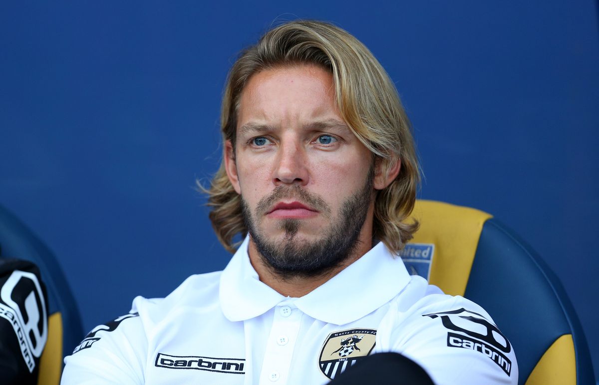 Alan Smith sits on the bench in a Notts County tracksuit