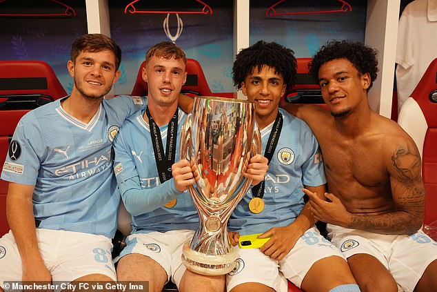 With fellow City academy graduates James McAtee, Cole Palmer and Rico Lewis after winning the UEFA Super Cup in 2023 - only Lewis remains at the club now