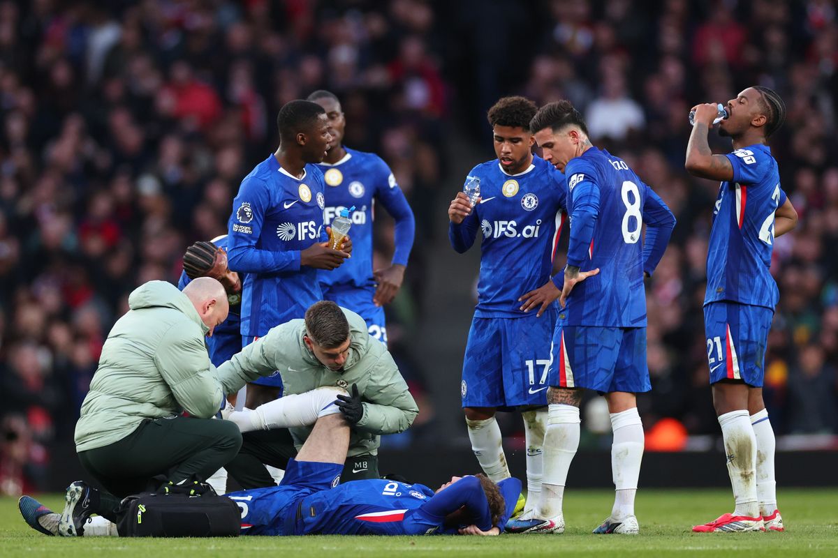 Teammates look on as Cole Palmer of Chelsea receives treatment for an injury during the Premier League match between Arsenal and Chelsea at Emirates Stadium