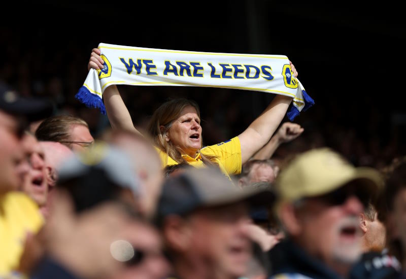 A Leeds United fan holds up a scarf at a match