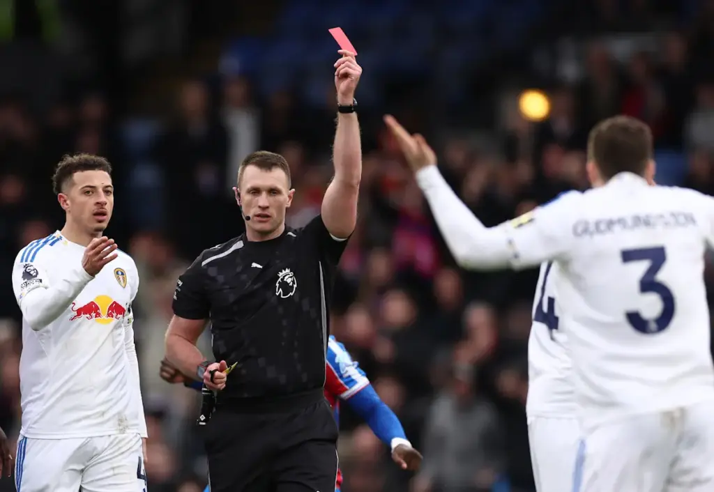 Gabriel Gudmundsson holds his arms up after being sent off by Leeds United as Ethan Ampadu watches on