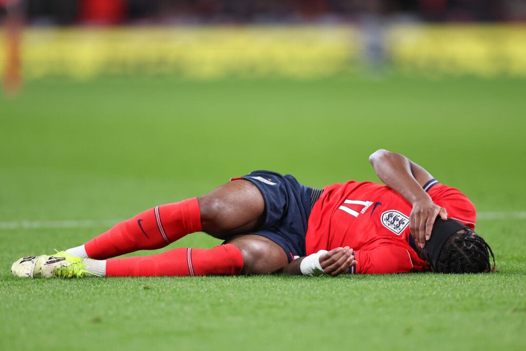 Noni Madueke looks to be in pain on the ground after suffering an injury during an England game