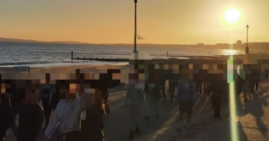 Large group of young people gather at Southbourne Beach