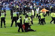 An injured steward is carried from the pitch