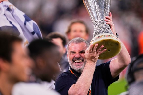 Ange Postecoglou holds up the Europa League trophy.