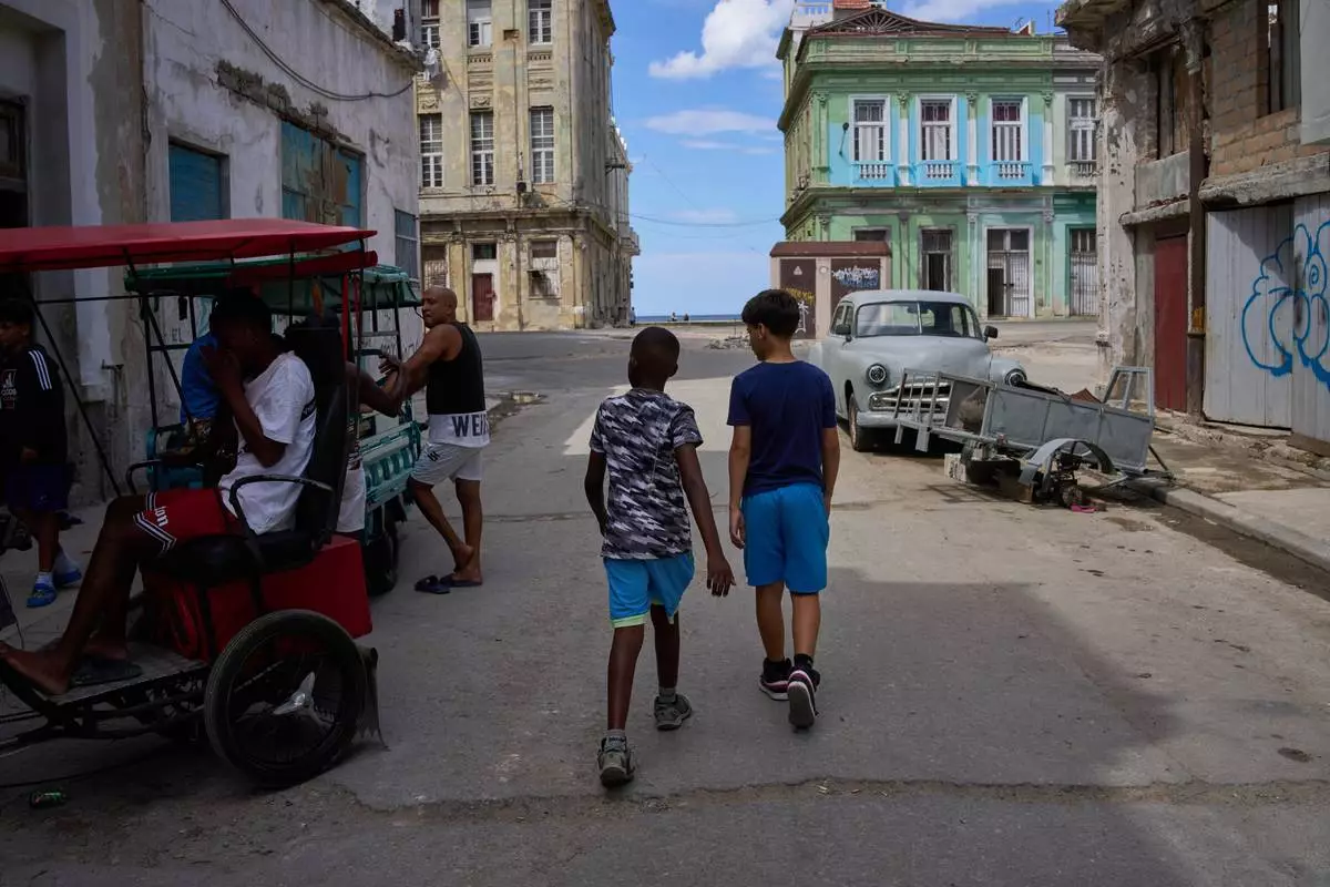 People walk outside during a blackout in Havana, Cuba, Monday, March 16, 2026. (AP Photo/Ramon Espinosa)