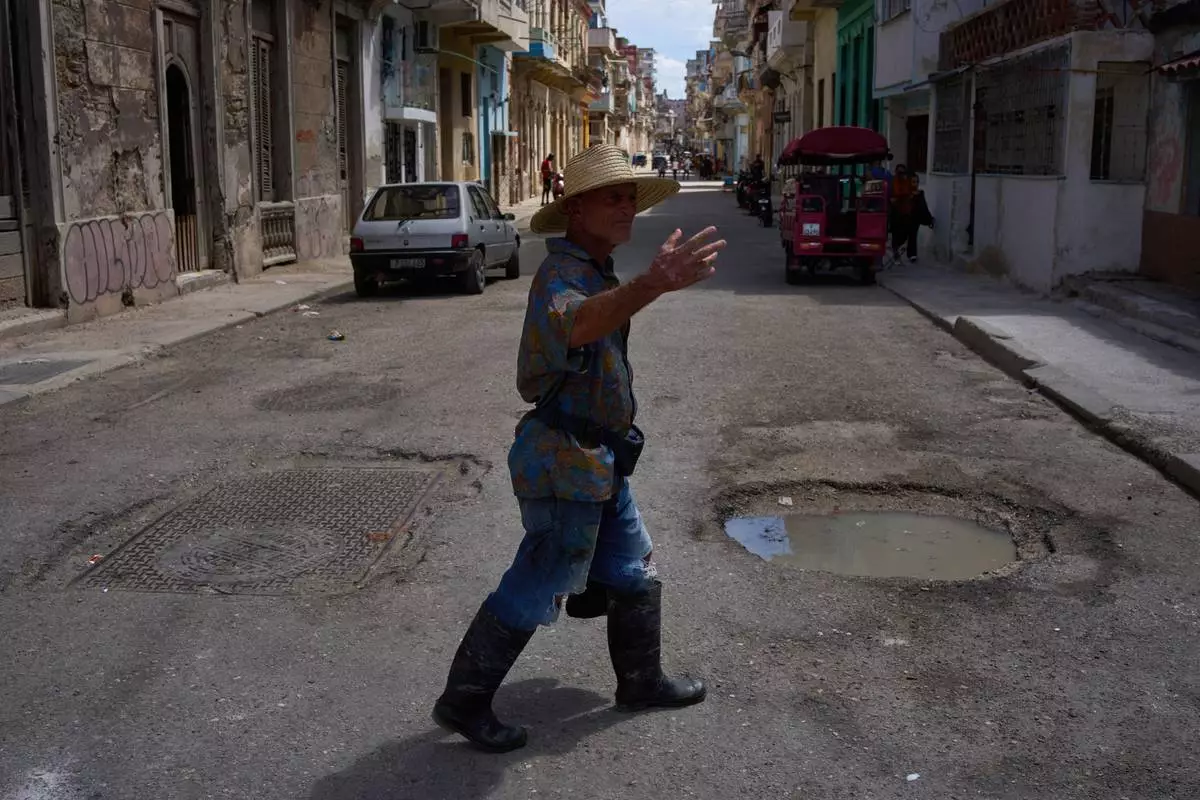 A man walks outside during a blackout in Havana, Cuba, Monday, March 16, 2026. (AP Photo/Ramon Espinosa)