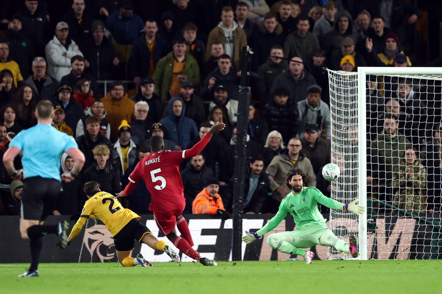 Rodrigo Gomes of Wolverhampton Wanderers scores his team's first goal past Alisson Becker of Liverpool