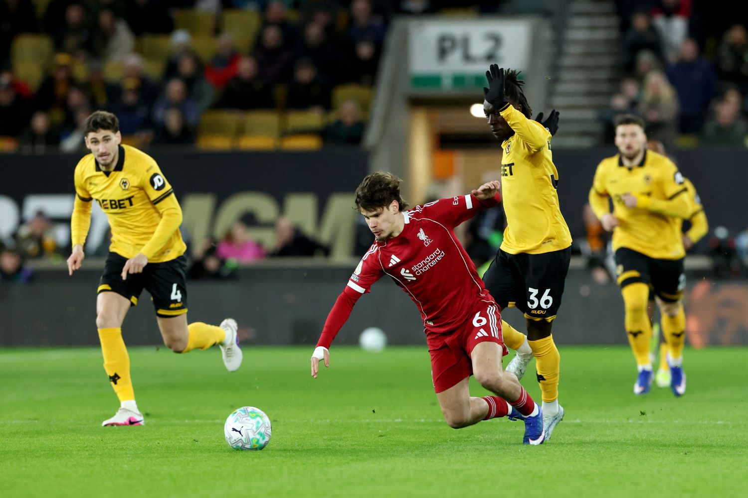 Milos Kerkez of Liverpool is challenged by Mateus Mane of Wolverhampton Wanderers