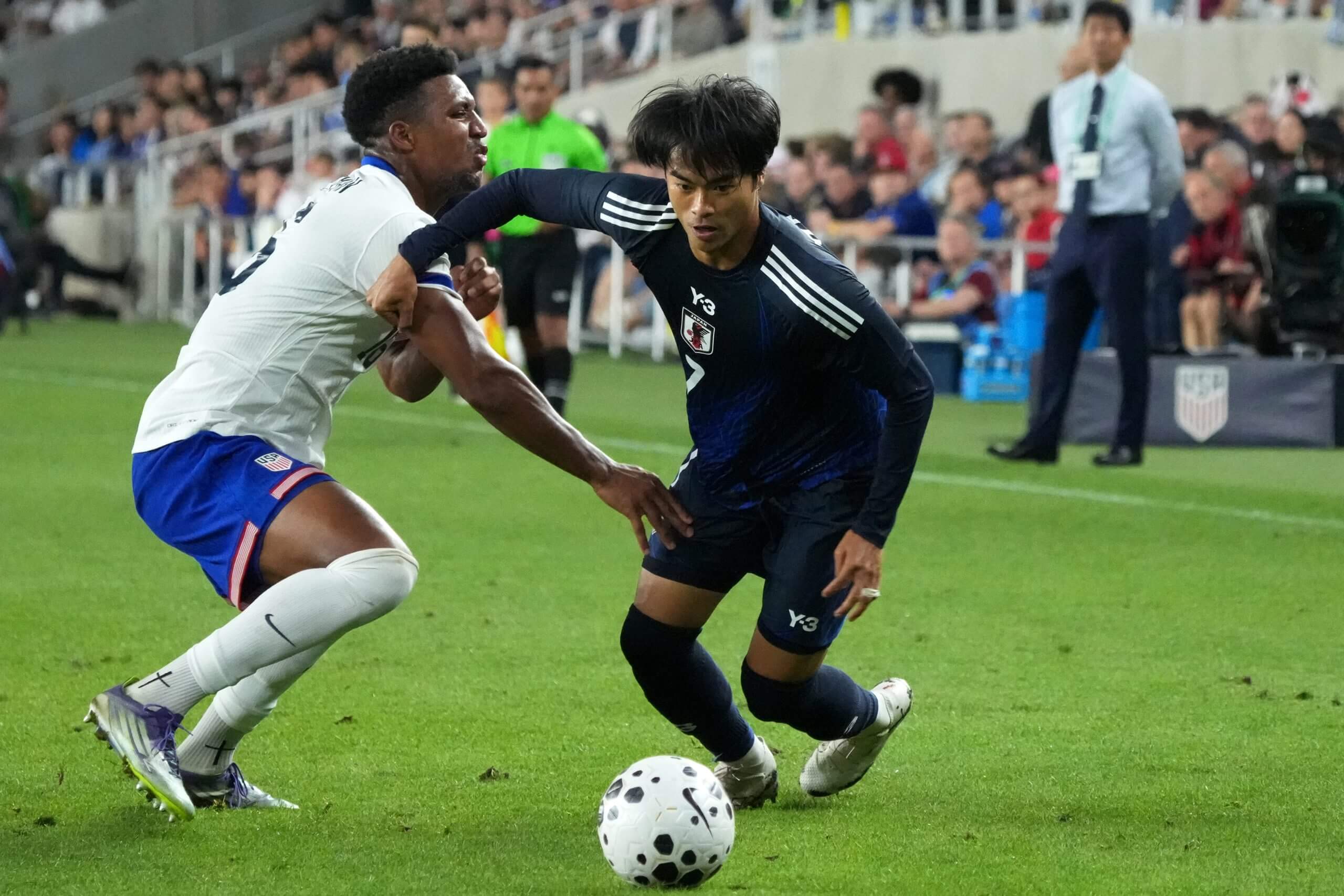 Kaoru Mitoma dribbles past an opponent 